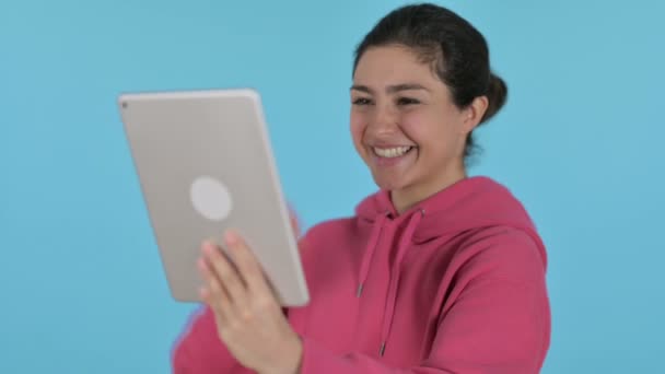 インドの女の子によるタブレット上のビデオ通話,青の背景 — ストック動画