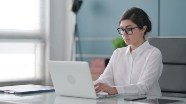 Indische Geschäftsfrau blickt im Büro mit Laptop auf Kamera — Stockvideo