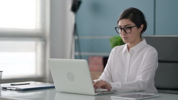Indische Geschäftsfrau denkt beim Arbeiten am Laptop im Büro — Stockvideo