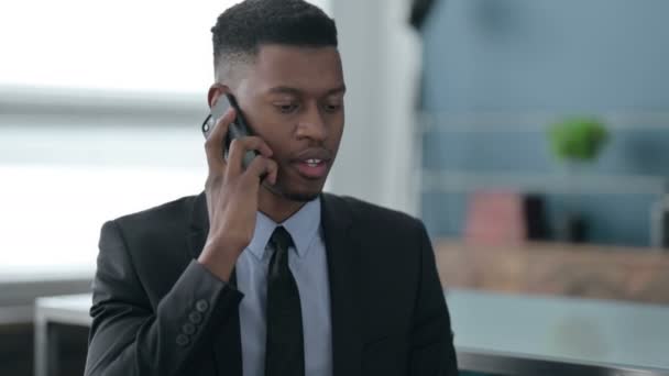 アフリカのビジネスマンの肖像｜スマートフォンで話す — ストック動画