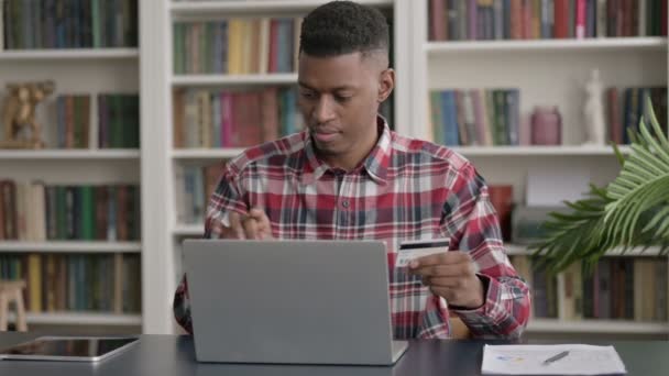 Hombre africano haciendo el pago en línea con éxito en el ordenador portátil — Vídeos de Stock