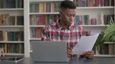 Dizüstü bilgisayarlı Afrikalı Ofiste Belgeler Okuyor 