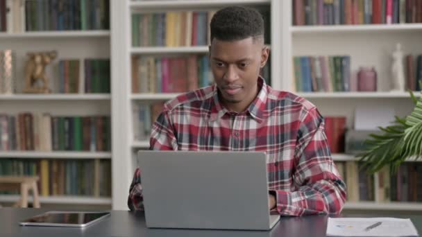 Afrikaanse man viert succes tijdens het gebruik van Laptop in Office — Stockvideo