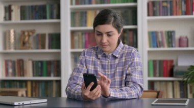 Ofiste akıllı telefon kullanan Hintli kadın. 