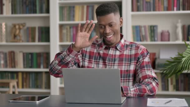 アフリカ人男性がオフィスのノートパソコンでビデオ通話で話す — ストック動画