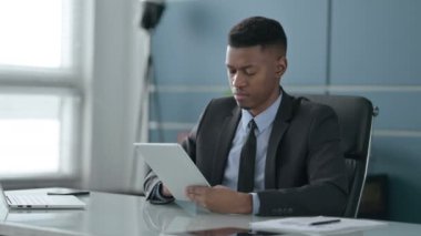 Ofiste otururken Tablet kullanan Afrikalı İşadamı