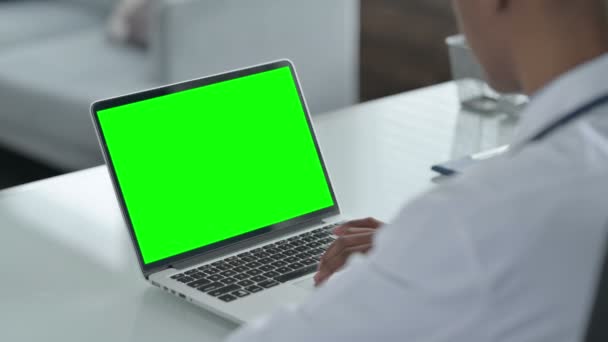 Vista trasera del médico africano utilizando el ordenador portátil con pantalla abierta — Vídeos de Stock