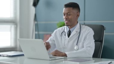 Ofisteki dizüstü bilgisayardan Afrikalı Doktor konuşuyor.