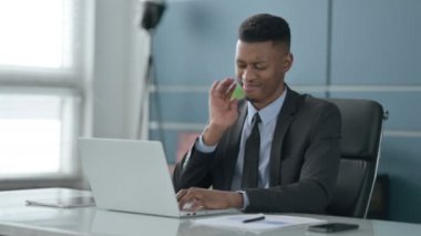 Ofiste dizüstü bilgisayar kullanırken boynu ağrıyan Afrikalı İşadamı 