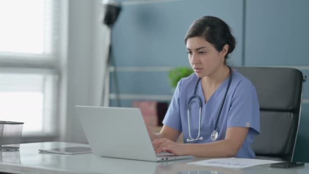 Indiska kvinnliga läkare som har huvudvärk när du arbetar på laptop — Stockvideo
