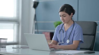 Ofiste dizüstü bilgisayar üzerinde çalışırken Hintli Kadın Doktor Düşünüyor