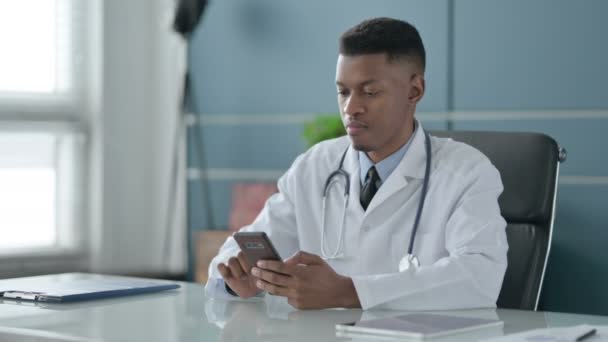 Afrikaanse arts praten op Smartphone in Office — Stockvideo