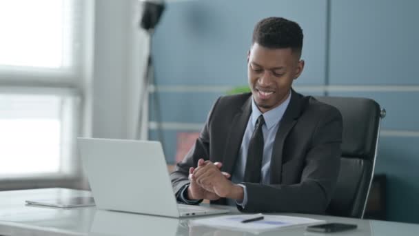 Homme d'affaires africain ayant la douleur au poignet tout en utilisant un ordinateur portable dans le bureau — Video