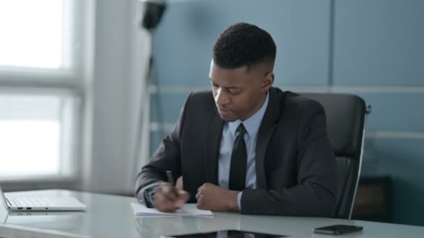 Homme d'affaires africain ayant déception lors de l'écriture sur papier — Video