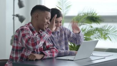 Afrikalı adam ve Hintli kadın laptopta video görüşmesi yapıyor. 
