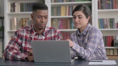 Afrikalı Adam ve Hintli Kadın Dizüstü bilgisayarda İş Tartışıyor 