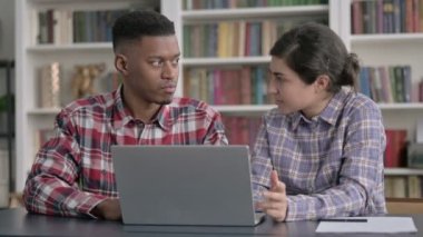 Dizüstü bilgisayarda çalışan Afrikalı Adam ve Hintli Kadın 