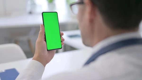 Doktor držící smartphone se zelenou obrazovkou Chroma Key — Stock fotografie