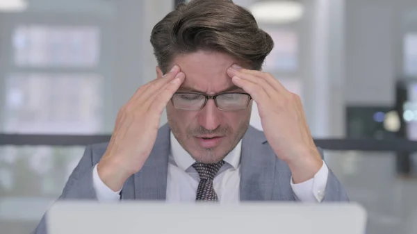 頭痛を持つラップトップを持つ中年ビジネスマンの閉鎖 — ストック写真