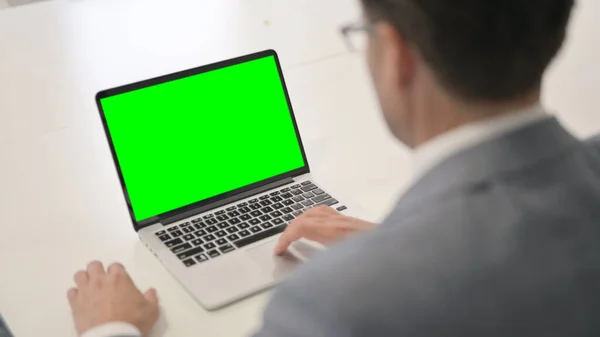 Hombre usando el ordenador portátil con pantalla de croma verde — Foto de Stock