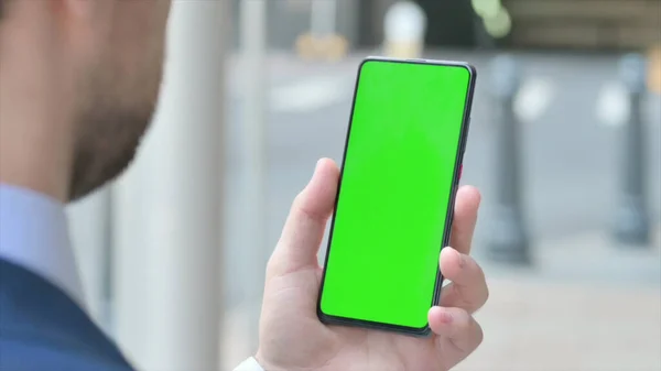 Mladý podnikatel používající Smartphone se zelenou obrazovkou — Stock fotografie