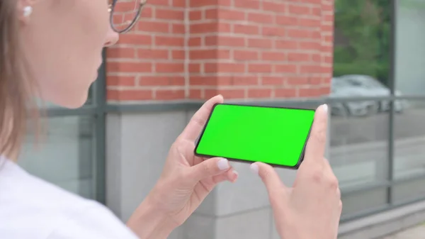 Chůze Žena Sledování Smartphone s Green Chroma Screen — Stock fotografie