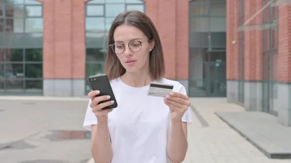 Молода жінка робить онлайн платежі на смартфоні — стокове фото