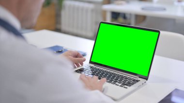 Yeşil Krom Ekranlı Laptop kullanan Doktor