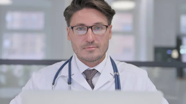 Zbliżenie lekarz z laptop patrząc w aparat — Zdjęcie stockowe
