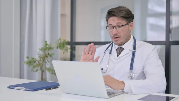 Доктор розмовляє на відеозв'язку ноутбуці в клініці — стокове фото
