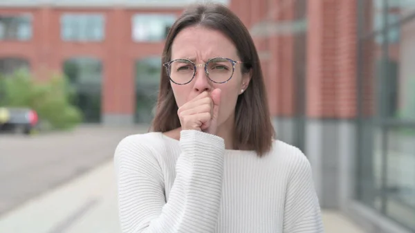 Хвора молода жінка кашель стоячи на відкритому повітрі — стокове фото