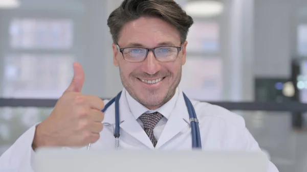 Primer plano del médico con el ordenador portátil mostrando pulgares hacia arriba —  Fotos de Stock