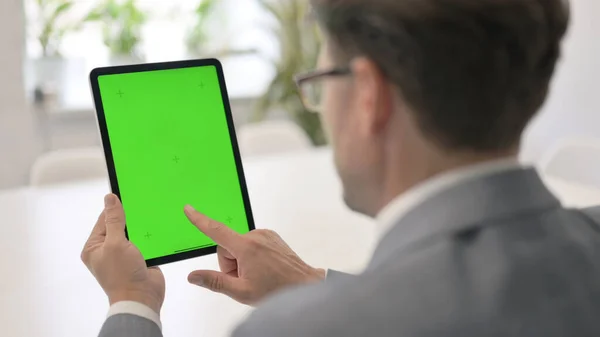 Homme regardant tablette avec écran Chroma vert — Photo