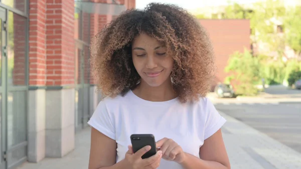 Fiatal afrikai nő Böngészés Internet Smartphone miközben séta kívül — Stock Fotó