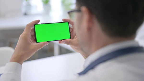 Doktor držící smartphone se zelenou obrazovkou Chroma Key — Stock fotografie