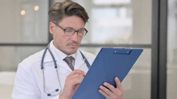 Retrato del médico revisando informes médicos — Foto de Stock