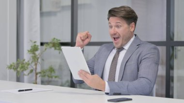 Ofisteki Tablette Başarıyı Kutlayan Orta Yaşlı Adam