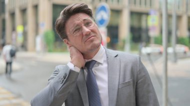 Orta yaşlı iş adamının boynu ağrıyor.