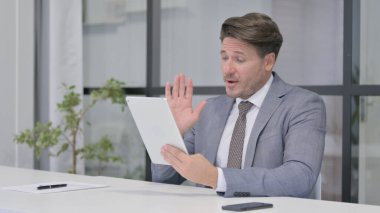 Orta Yaşlı Adam Ofisteki Tablet 'te Video Çağrısı Yapıyor