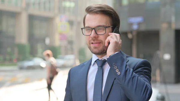 Venkovní mladý podnikatel mluví na telefonu — Stock fotografie