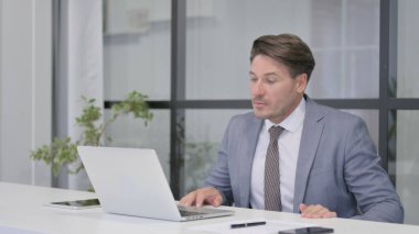 Orta yaşlı adam işten sonra ofisten ayrılıyor