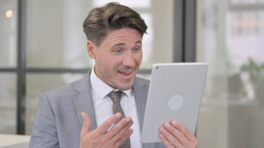 Ofisteki Orta Yaşlı Adam 'dan Tablet' e Görüntü Çağrısı