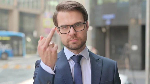 中指を示す屋外積極的な若いビジネスマン — ストック写真