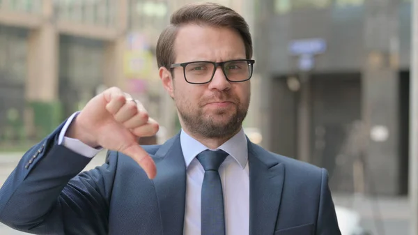 Empresario joven al aire libre mostrando pulgares hacia arriba — Foto de Stock