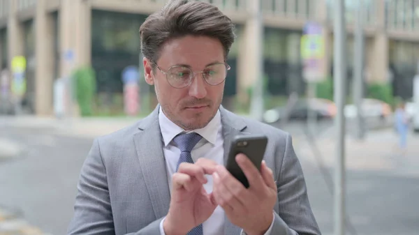 Geschäftsmann mittleren Alters surft mit dem Smartphone im Internet — Stockfoto