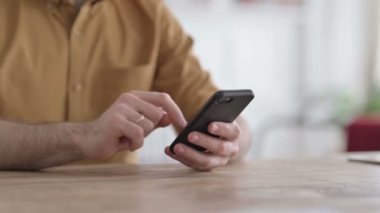 Akıllı telefon kullanan genç adamın ellerini kapat. 