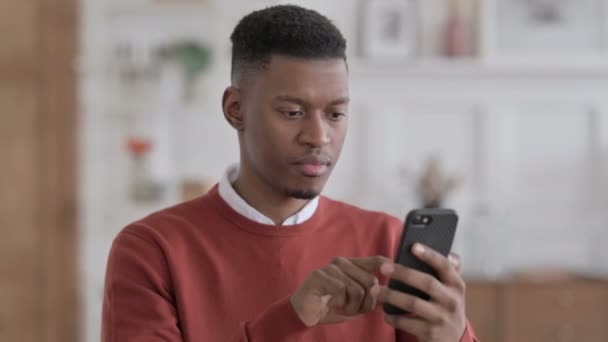 Portré az afrikai üzletemberről, aki az okostelefonon reagál a veszteségre — Stock videók
