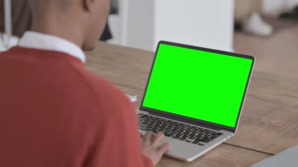 Hombre africano trabajando en el ordenador portátil con pantalla de croma verde — Vídeos de Stock