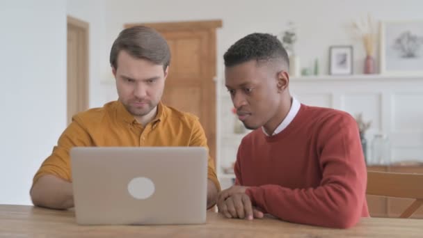 Hombre africano y hombre joven celebrando el éxito en el ordenador portátil — Vídeo de stock