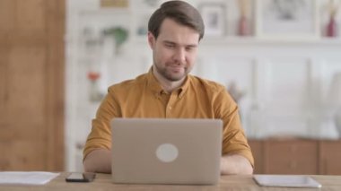 Ofiste dizüstü bilgisayar kullanırken Başarı Kutlaması Genç Adam